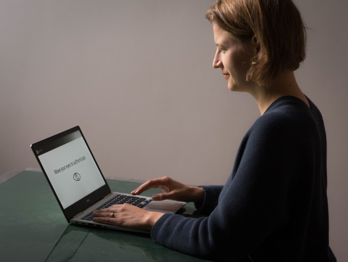 Eine Frau sitzt vor einem Laptop.